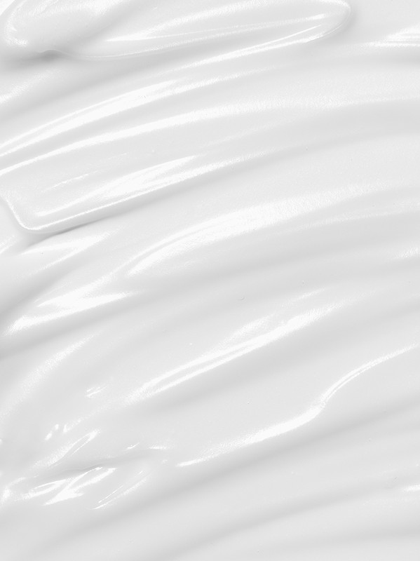 Close-up of smooth, glossy white cream or lotion, swirled to create ridges. Monochromatic, bright lighting, product shot.