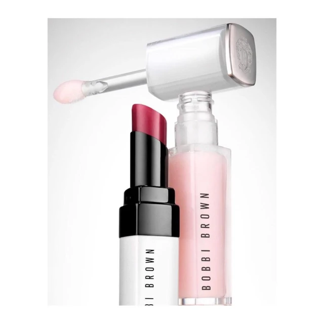 Close-up studio shot of a pink lip gloss tube and a red lipstick tube by Bobbi Brown cosmetics, against a white background.