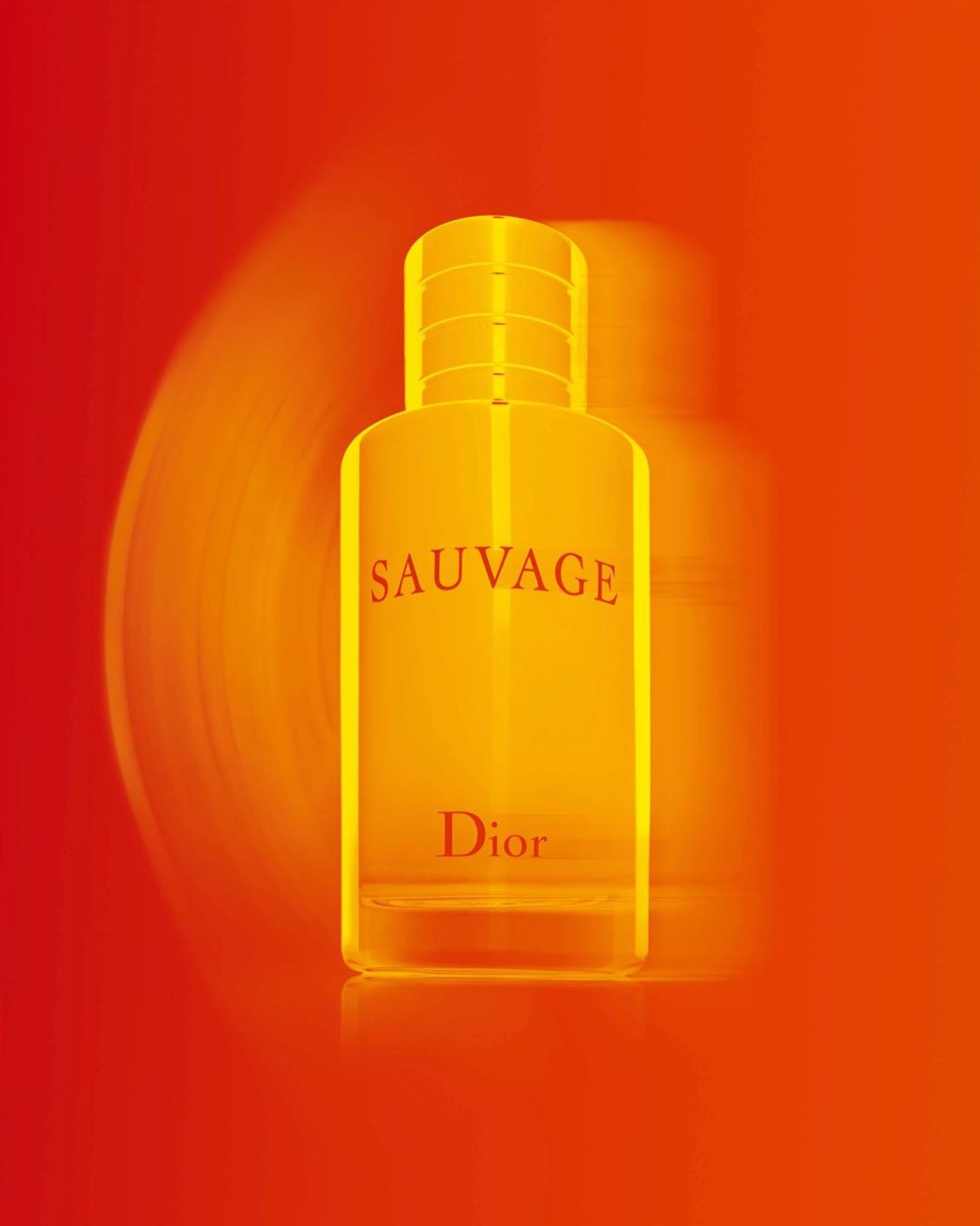 Product shot of a 'Sauvage Dior' branded perfume bottle with a red and orange gradient background and motion blur effect.
