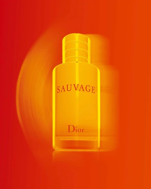 Product shot of a 'Sauvage Dior' branded perfume bottle with a red and orange gradient background and motion blur effect.
