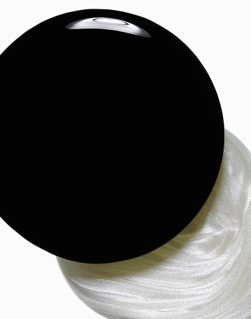 Close-up shot of contrasting black and white liquid swirls creating a dynamic, abstract composition against a white background.