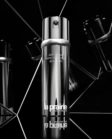 La Prairie silver skincare bottle with reflective surfaces, angled lighting, and a black background for a luxurious aesthetic.