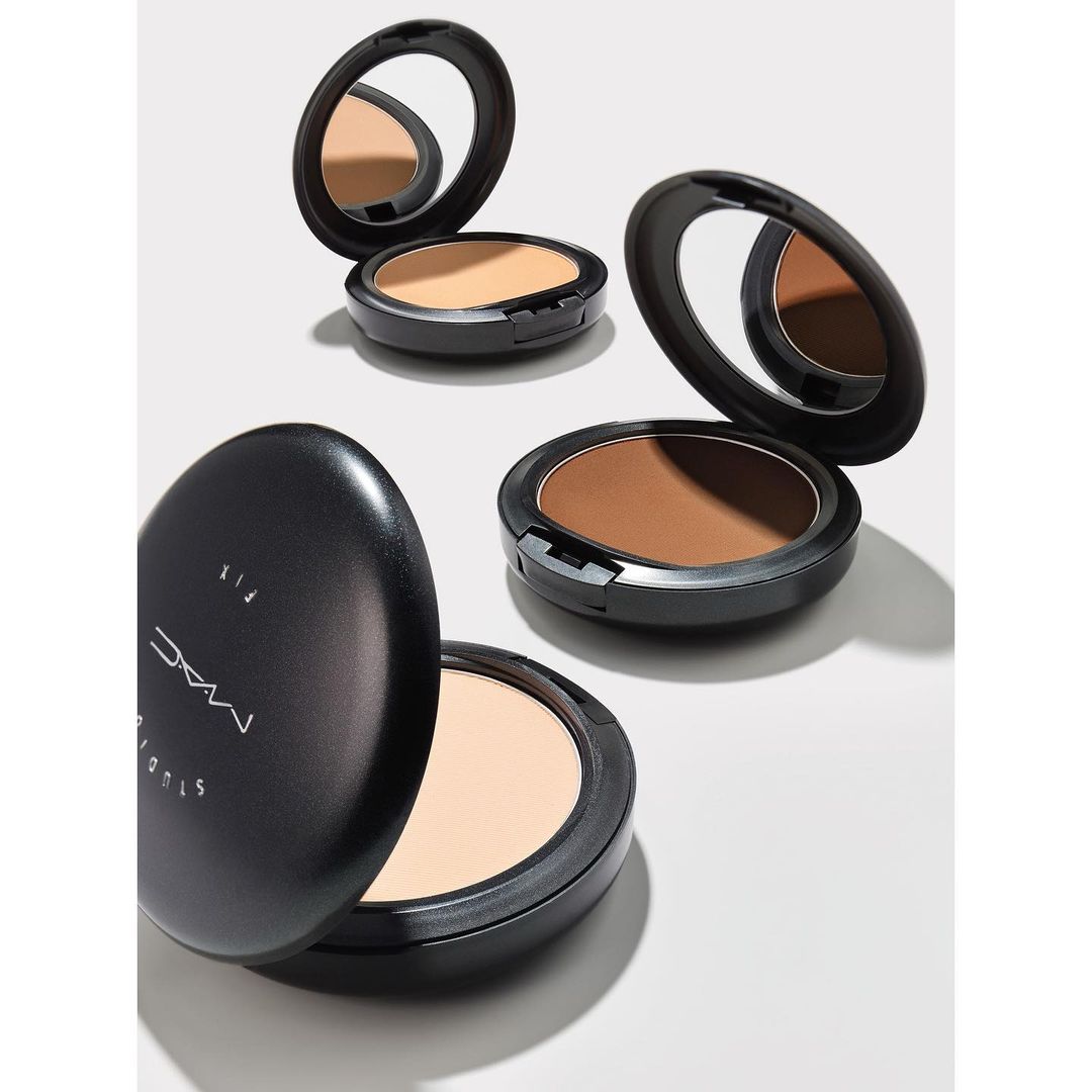 Studio shot of MAC Studio Fix powder foundation compacts in varying shades on a white surface with natural light and minimal shadows.