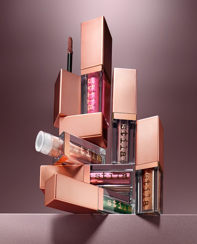 Still life of Stila liquid eyeshadows in various colors. The makeup products are arranged in a staggered pyramidal shape.