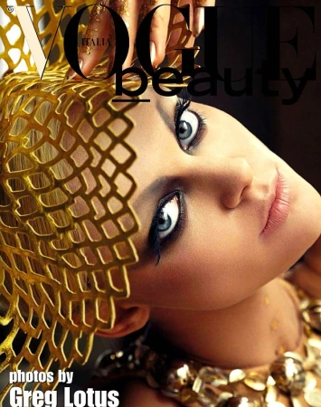 Beauty editorial shot of a woman wearing golden headwear with dramatic eye makeup, as seen on the cover of Vogue Italia magazine.