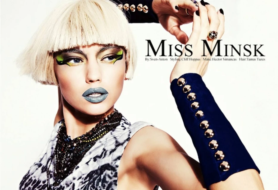 Editorial fashion shot: Woman with avant-garde makeup and a blonde bob haircut, posing in a studio with dramatic lighting and bold accessories.