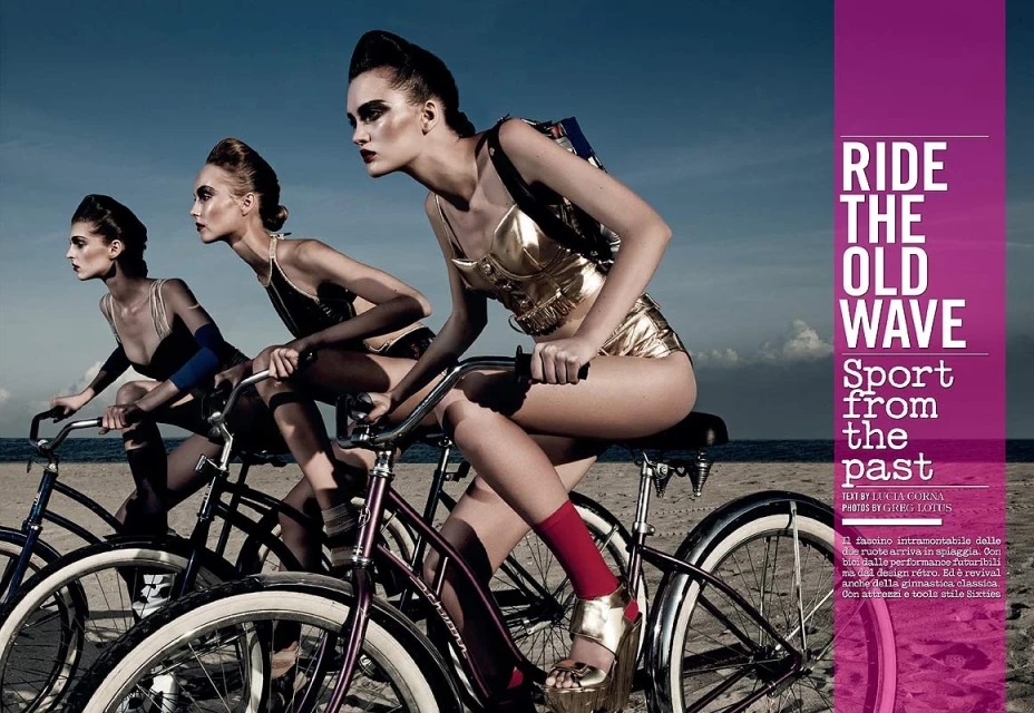 Three women in retro bathing suits ride bicycles on a beach with dramatic makeup, showcasing a vintage-inspired sport fashion editorial.