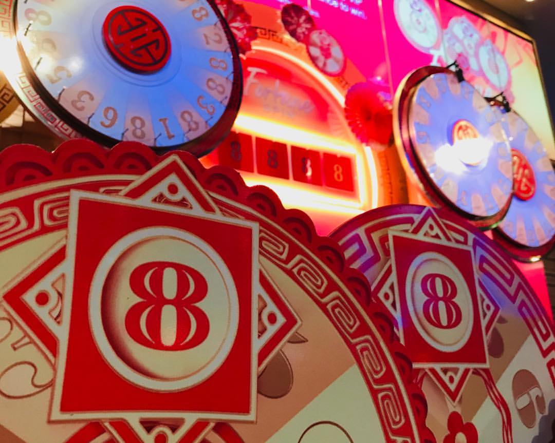 Casino game with multiple illuminated wheels displaying the number eight in red and gold, creating a lucky, festive atmosphere.
