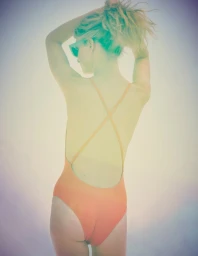 Blonde woman wearing a vibrant orange swimsuit and sunglasses, posing from behind with her hands up in her hair against a soft gradient background