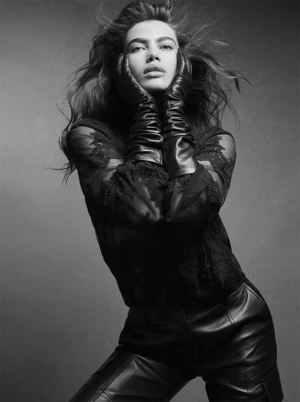Black and white portrait of a woman wearing long leather gloves and leather pants, holding her face in New York.