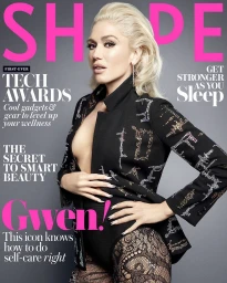 Gwen Stefani on magazine cover wearing embellished black jacket and patterned tights against a grey studio background