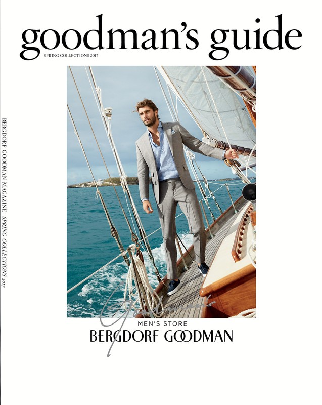 Bergdorf Goodman magazine cover featuring a man in a grey suit on a sailboat with blue water in the background on a sunny day.