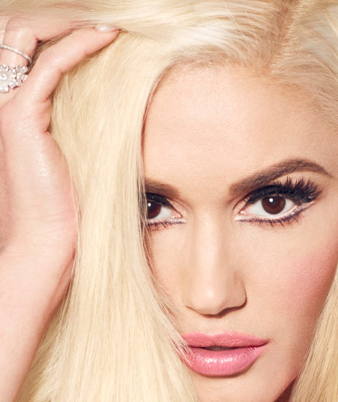 Close-up of a woman with blonde hair and pink lipstick. She is looking directly at the camera with a neutral facial expression.