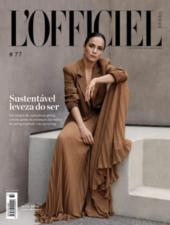 Woman in brown blazer and pleated skirt seated on concrete steps for magazine cover