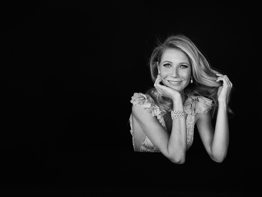 Gwyneth Paltrow in a ruffled dress against a black background, photographed by James White.