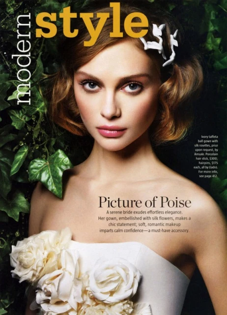 Magazine cover featuring a serene bride in an ivory gown embellished with silk flowers, complemented by soft, romantic makeup.