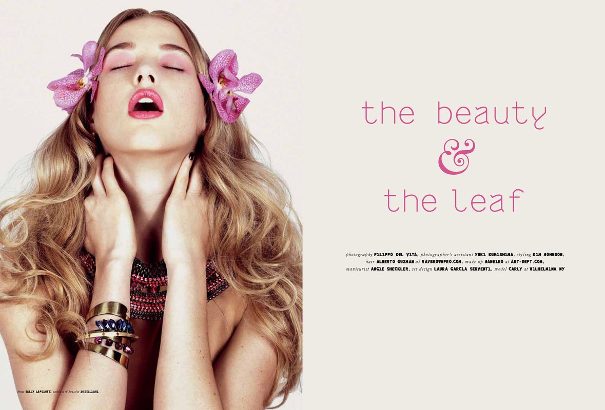 Fashion editorial shot of a young woman with blonde wavy hair, closed eyes, fair skin, light pink eyeshadow, and pink orchid hair accessories.
