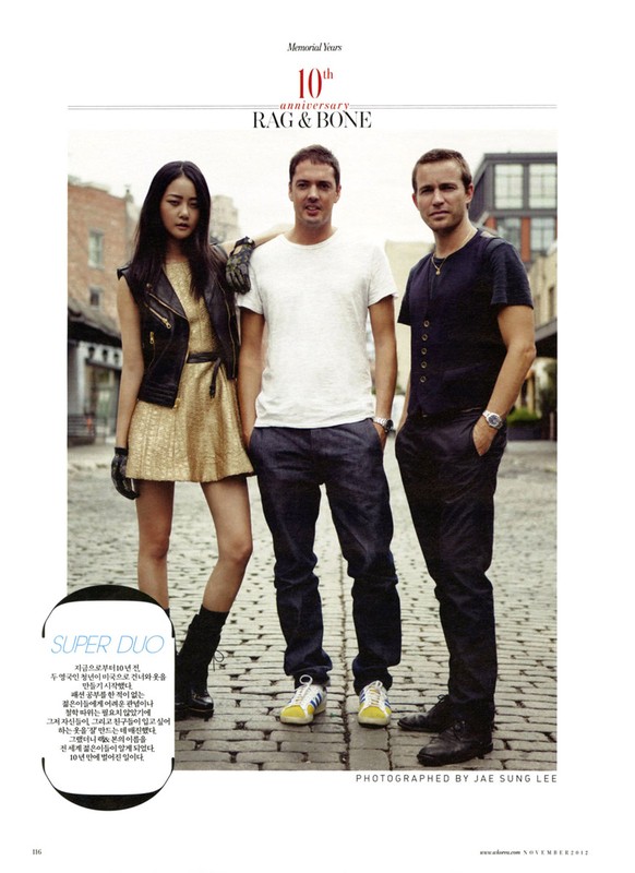 Fashion editorial photo with three people standing on a brick street: an Asian woman in a gold dress and two Caucasian men.