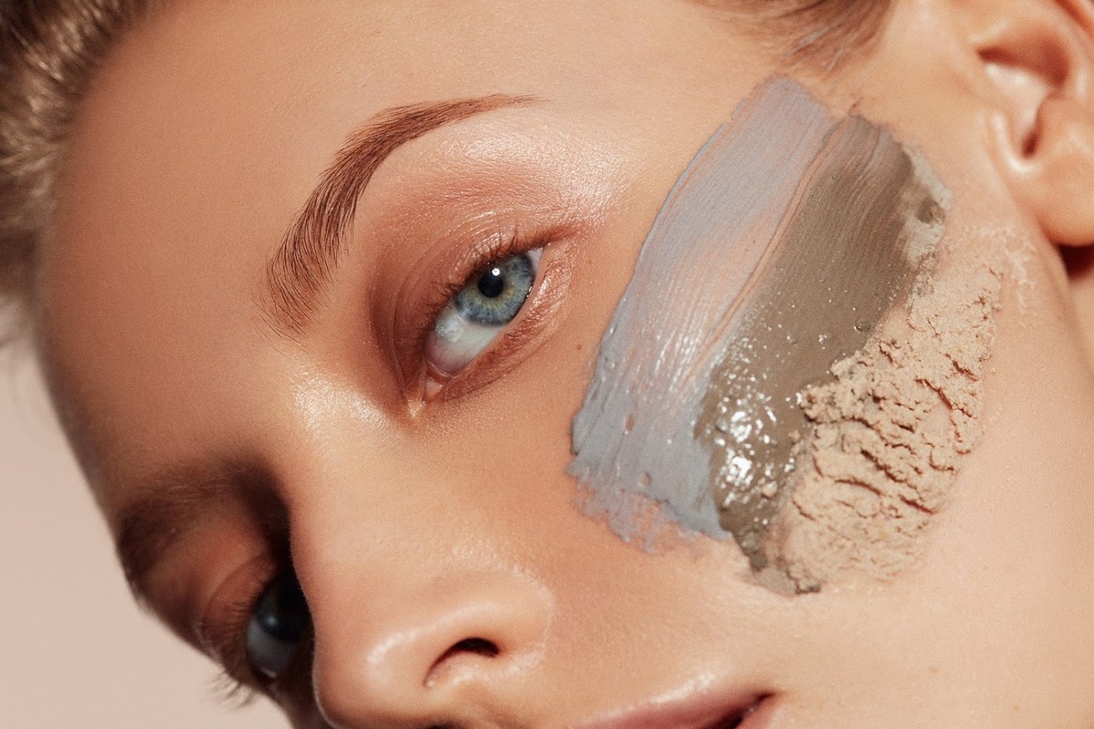 Close-up of a woman's face with skincare product applied to her cheek, highlighting beauty and skincare in a studio setting.