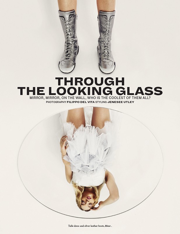 Fashion editorial shot featuring silver boots and a reflection of a woman in a mirror against a white background, studio setting.