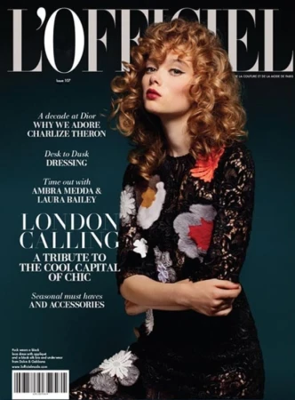 Magazine cover featuring a woman with curly hair wearing a floral-patterned dress, against a dark teal background with title text.