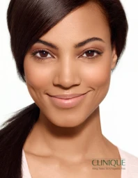 Close-up beauty portrait of a smiling woman with dark hair and natural makeup against a white background