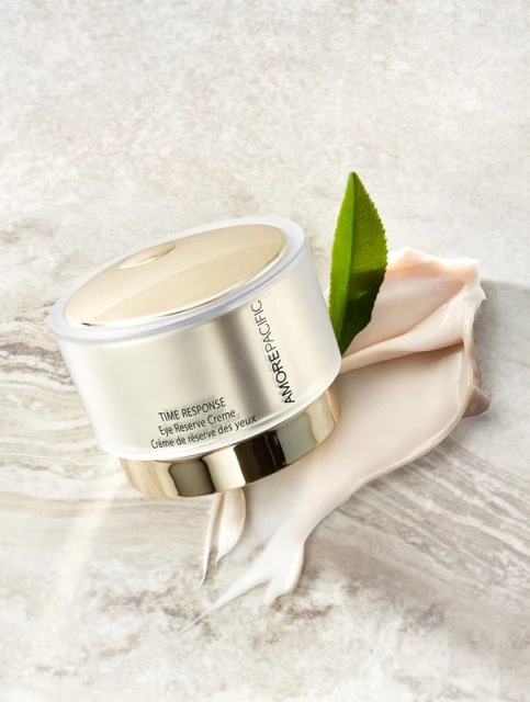 Amorepacific skincare product jar on a marble surface with a leaf and cream, photographed in a soft, studio setting.