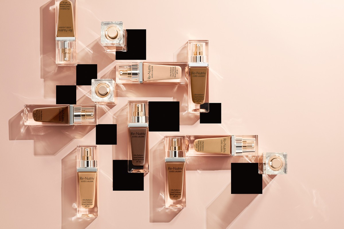 Cosmetic product photography featuring Estée Lauder Re-Nutriv foundation bottles and compacts arranged on transparent acrylic pedestals.