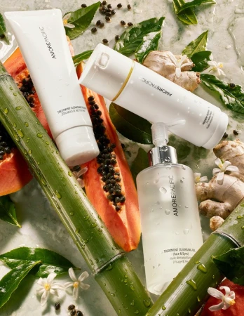 Amorepacific cleansing products sit amongst greenery and fruit, presenting a visually appealing display of skincare and natural elements.