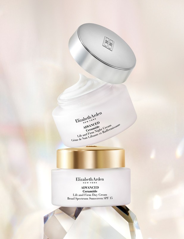 Three stacked Elizabeth Arden Advanced Ceramide Lift and Firm face creams in white jars with silver and gold lids on clear facets.