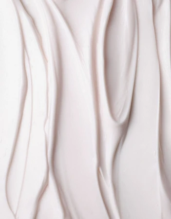 Close-up of rippled, light pink beauty cream filling the frame, showcasing a smooth, soft texture and subtle color variations.