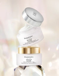 Two stacked skincare cream jars with a floating silver cap and white cream swirl against a soft abstract background
