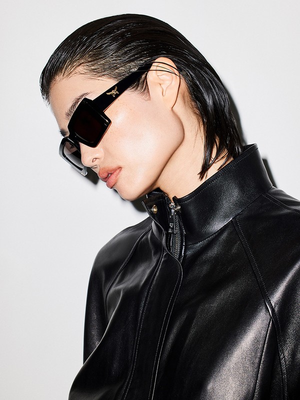 Model wearing black sunglasses and a black leather jacket against a white background by Jeremy Liebman.