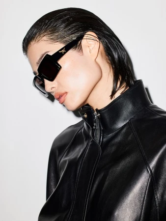 Model wearing black sunglasses and a black leather jacket against a white background by Jeremy Liebman.