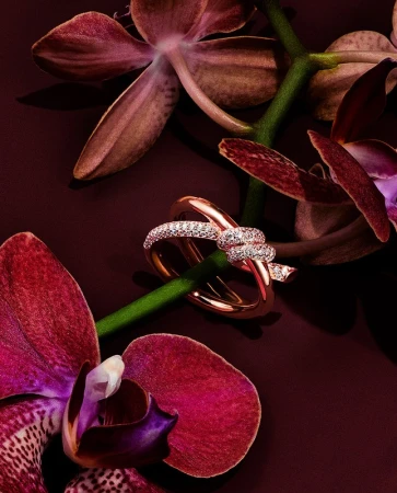 Elegant rose gold ring adorned with diamonds set against vibrant magenta orchids, creating a luxurious and romantic jewelry still life.