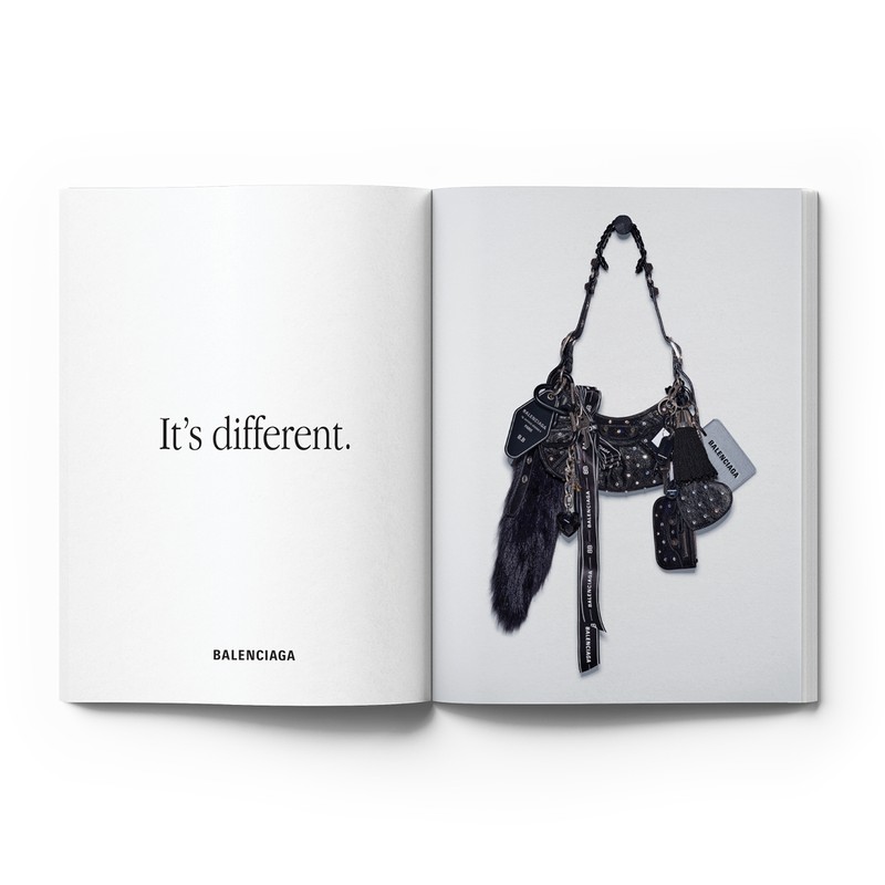 Open book spread features a Balenciaga bag on the right page, displayed against a white background, with text on the left page.