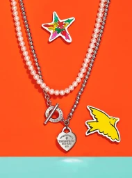 Layered pearl and silver bead necklaces with heart pendant on vibrant orange and turquoise background styled by Jocelyne Beaudoin