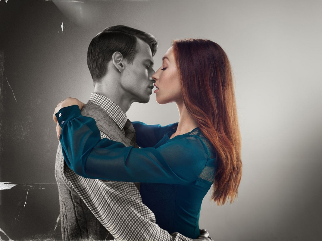 Close-up image of a couple embracing in a studio, half the image is in black and white, half is in color, studio lighting.