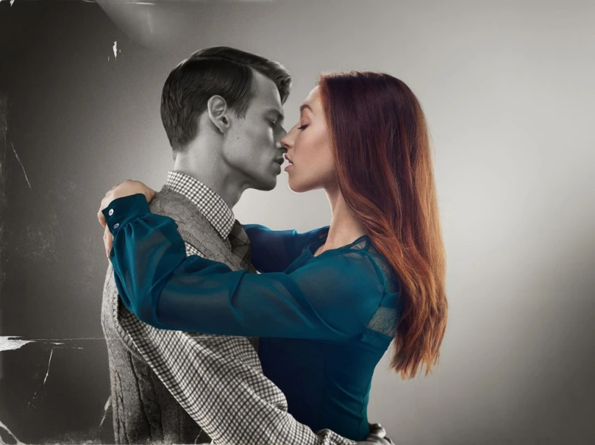 Close-up image of a couple embracing in a studio, half the image is in black and white, half is in color, studio lighting.