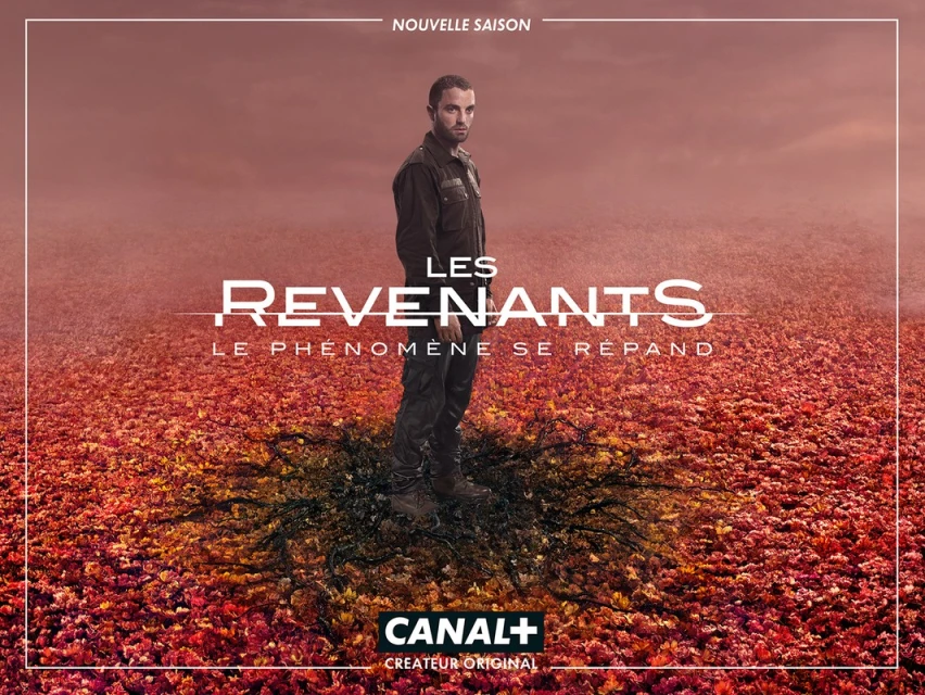 Poster image for the TV show Les Revenants (The Returned). Man in dark clothing stands in a field of red and orange leaves.