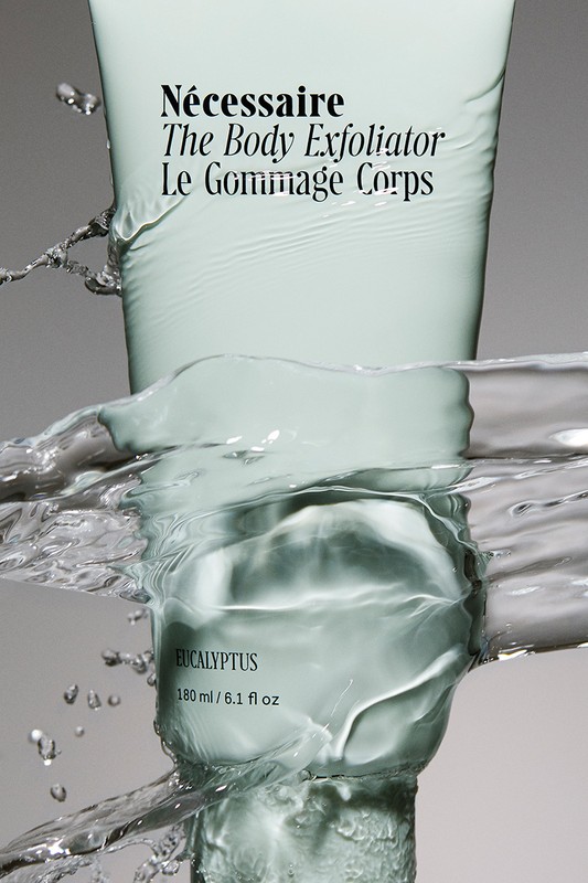 Necessaire The Body Exfoliator product shot. Skin care product in water, studio shot of body care product for advertising campaign.