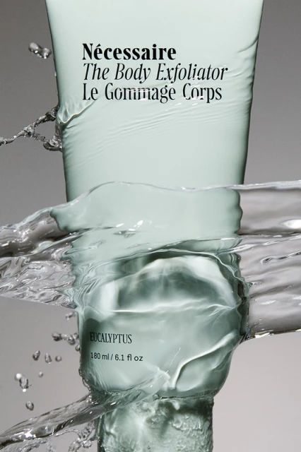 Necessaire The Body Exfoliator product shot. Skin care product in water, studio shot of body care product for advertising campaign.