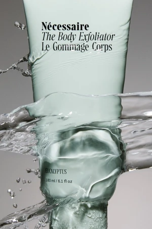 Necessaire The Body Exfoliator product shot. Skin care product in water, studio shot of body care product for advertising campaign.