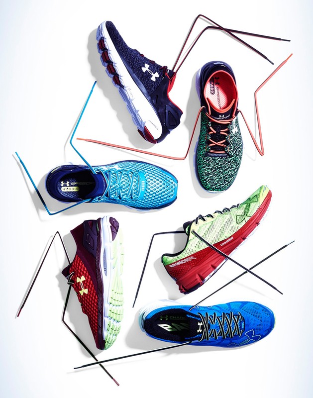 Six Under Armour running shoes of different colors arranged on a white background, top-down view, lit with studio lighting.