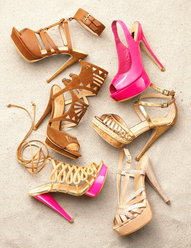 Collection of high-heeled open toe platform sandals and stilettos in tan, gold, and pink hues arranged on a neutral surface.