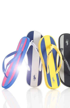 Four pairs of Ralph Lauren striped flip-flops in blue, yellow, white, and black. Summer footwear featuring the RL polo logo.