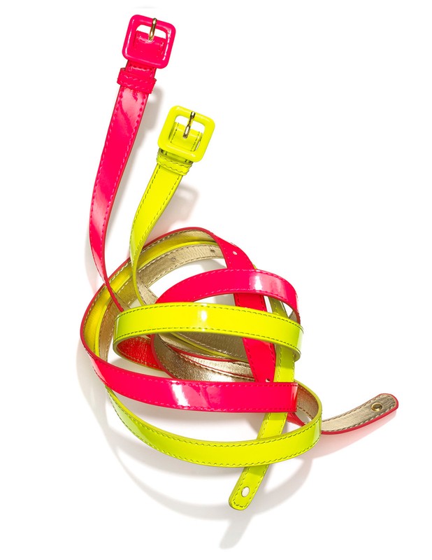 A vibrant, high-key product shot showcases a pair of glossy neon belts, one yellow, one pink, intertwined on a clean white backdrop.