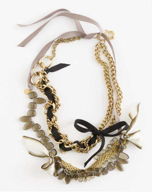 Elegant gold chain necklace with ribbons, beads, and various chain styles on a white background for fashion and accessories.