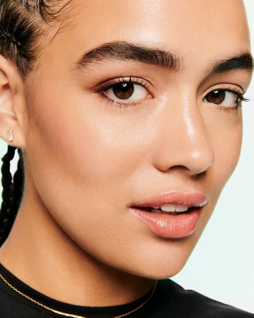 Close-up portrait of a woman with braided dark hair wearing a black top against a plain light background