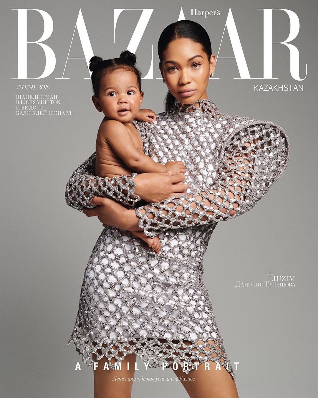 Harper's Bazaar cover with Chanel Iman holding a baby, both in stylish outfits, against a solid grey backdrop. Family portrait.